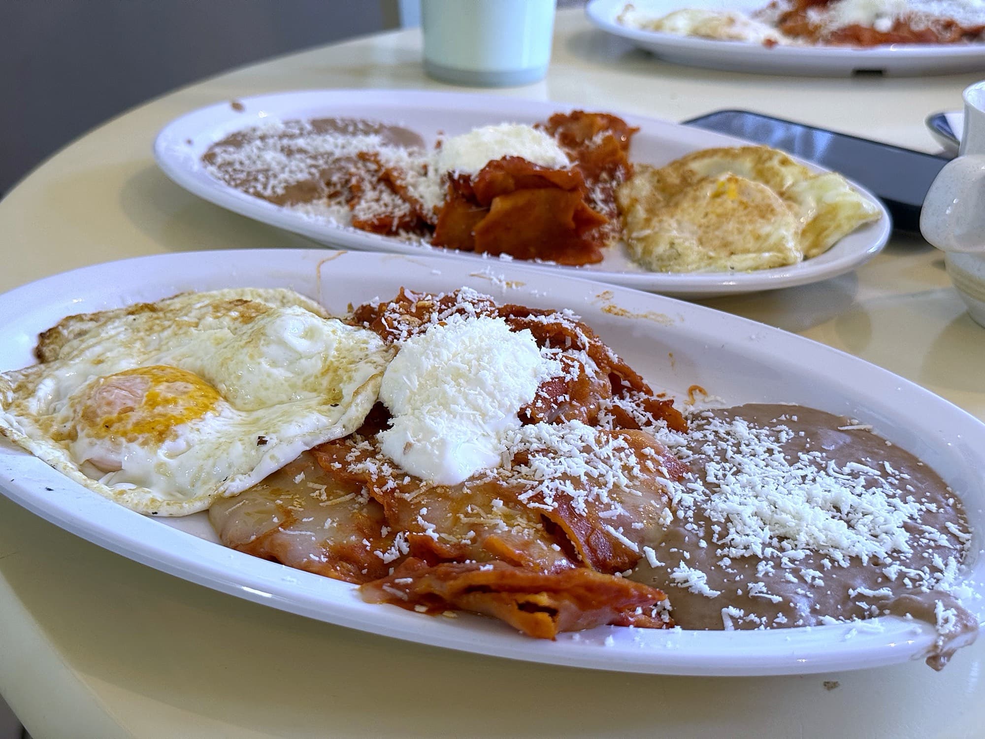 Chilaquiles rojos con huevo estrellado servidos en la mesa